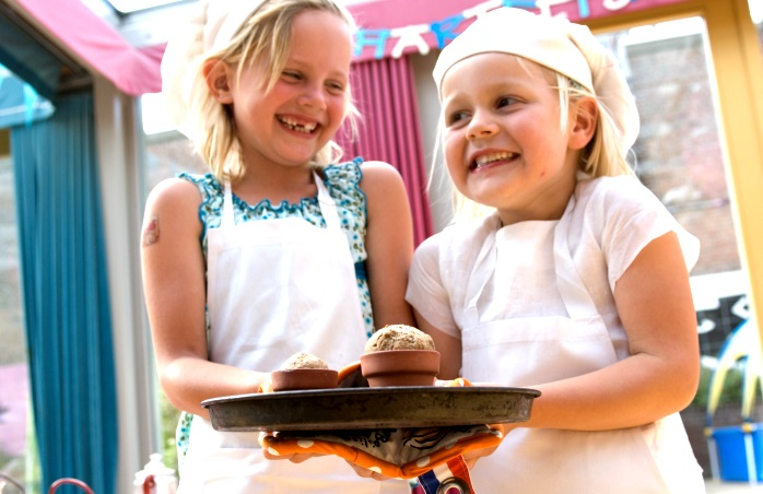 2 genç aşçı Kinderkookkafe’de eğlenirken.
