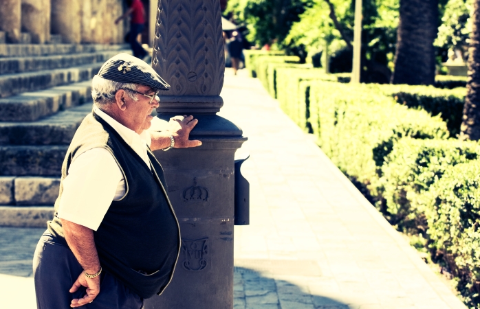 İspanya'da gezilecek yerler- Sıcak bir yaz gününde elektrik direğinin yanında dinlenen yaşlı bir Sevilla'lı.