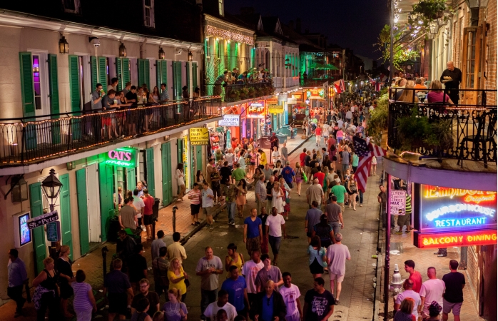 Aydınlık bir yaz akşamında New Orleans’ın en ünlü caddesinde dolaşanlar.