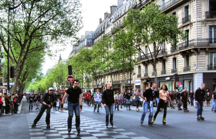 Yazın hoş bir Pazar gününde Paris sokaklarını patenlerle dolaşan kalabalık bir grup.