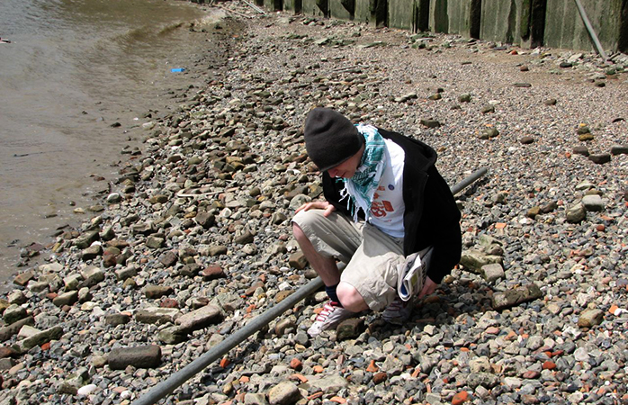 A teenager rests during a mudlarking session by the Thames.