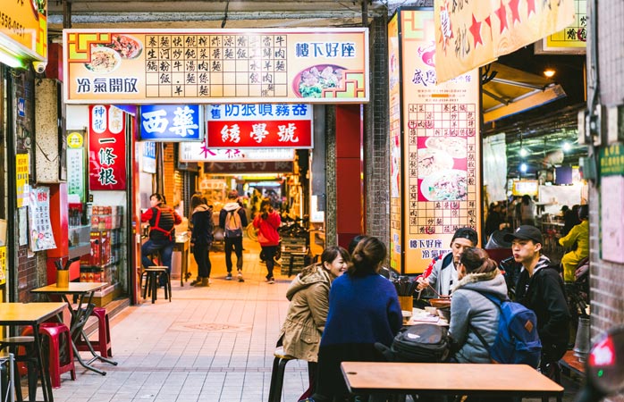 Tayvan’ın en iyi sokak yiyeceklerinden atıştırırken sohbet eden bir arkadaş grubu