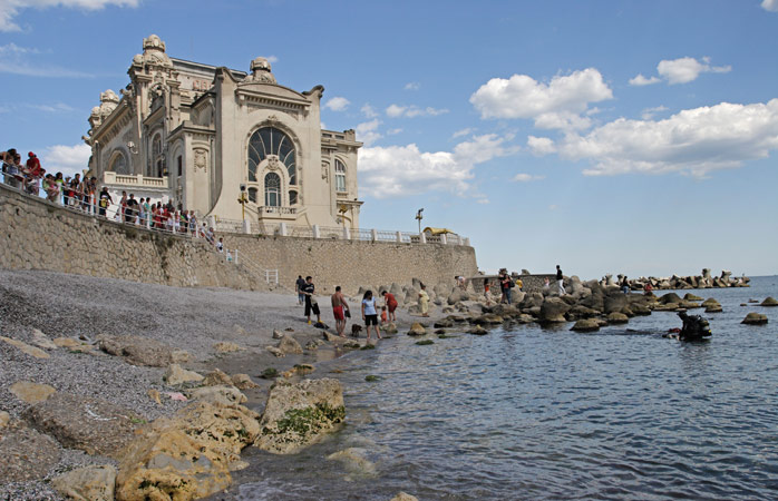 popüler tatil yerleri- Romanya’daki terk edilmiş Constanta Kumarhanesi’nin altındaki kayalıklarda gezinen ziyaretçiler