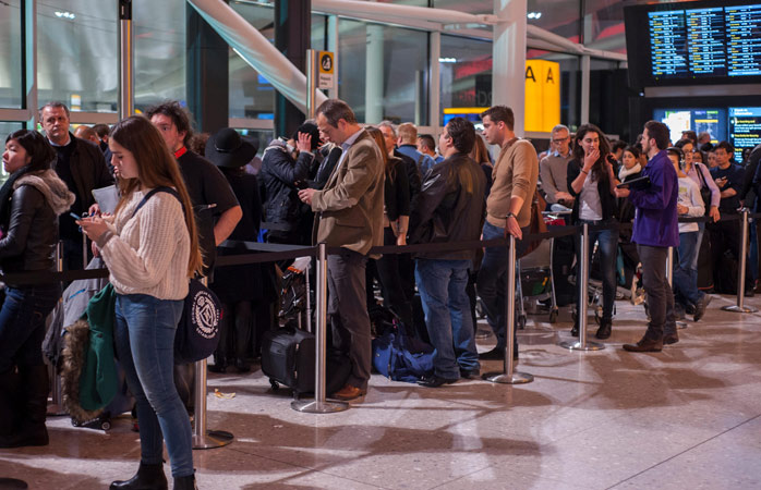 Yolcular Londra, Birleşik Krallık’taki Heathrow Havalimanı’nda, uçağa binmek için sıra bekliyor