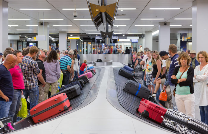 Yolcular Amsterdam, Hollanda’daki Schiphol Havalimanı’nda bavullarını bagaj teslim yerinden almak için sabırla bekliyor