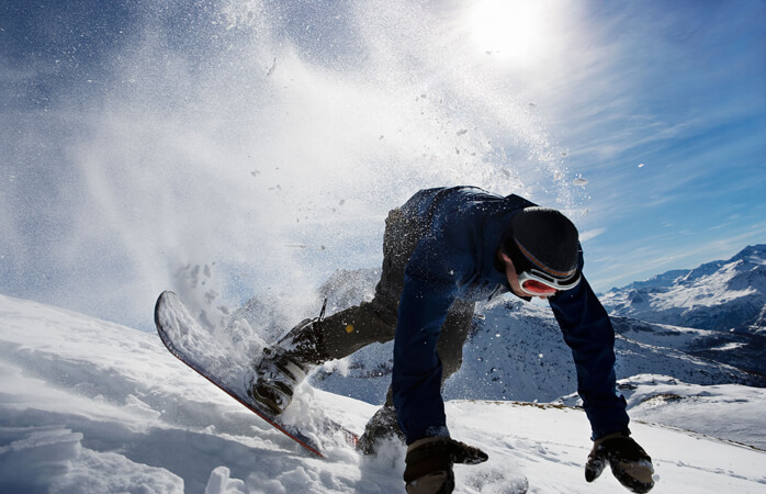 Seyahat sigortası: Karlı bir pistte iniş yaparken dengesini kaybeden bir snowboardcu